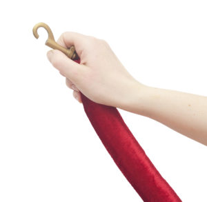 Human hand opening red velvet rope